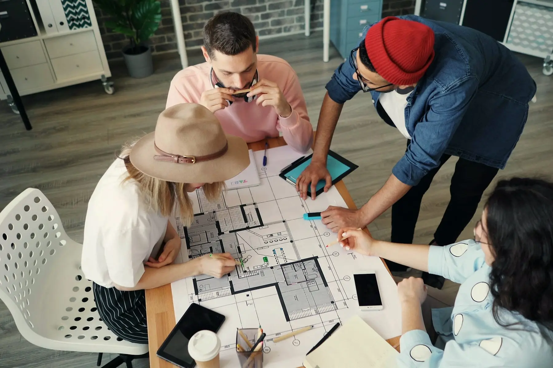 Équipe penchée sur des plans de construction autour d'une table