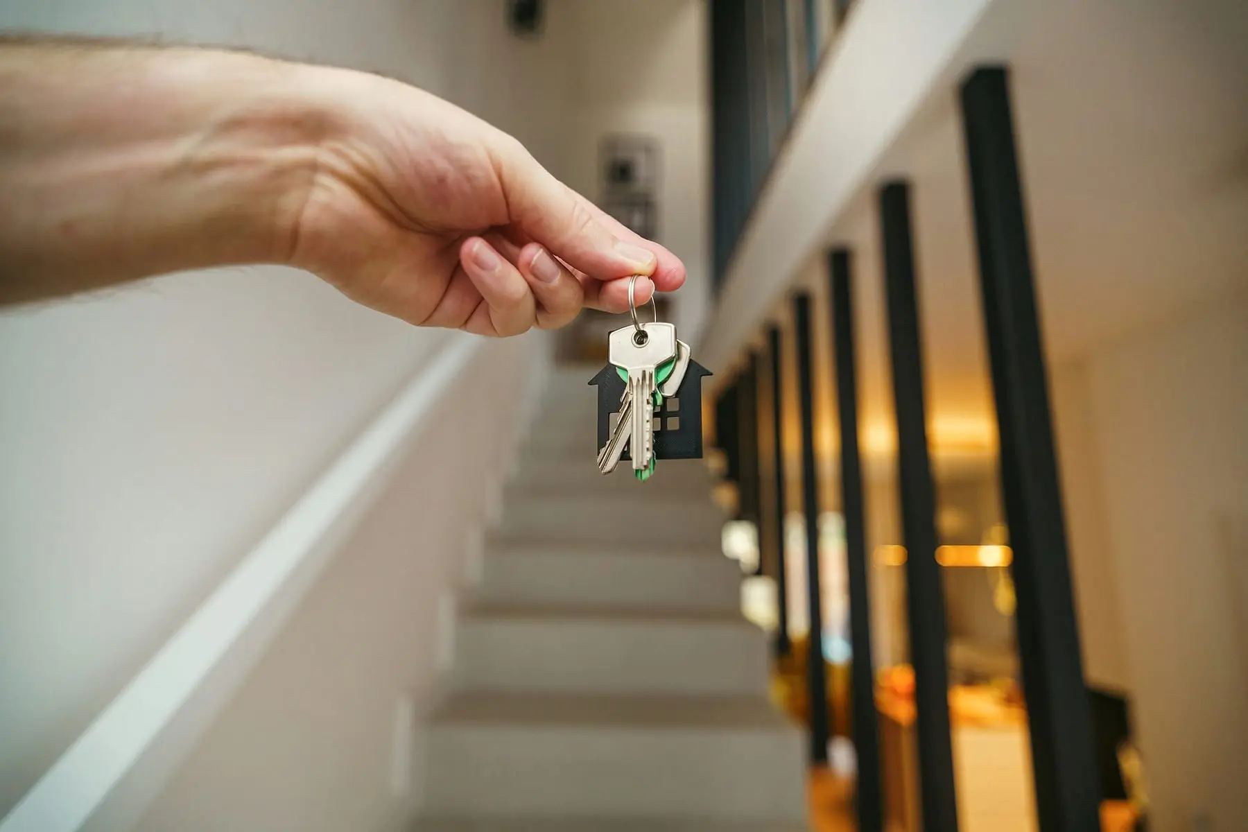 Remise des clés d'un appartement devant un escalier éclairé