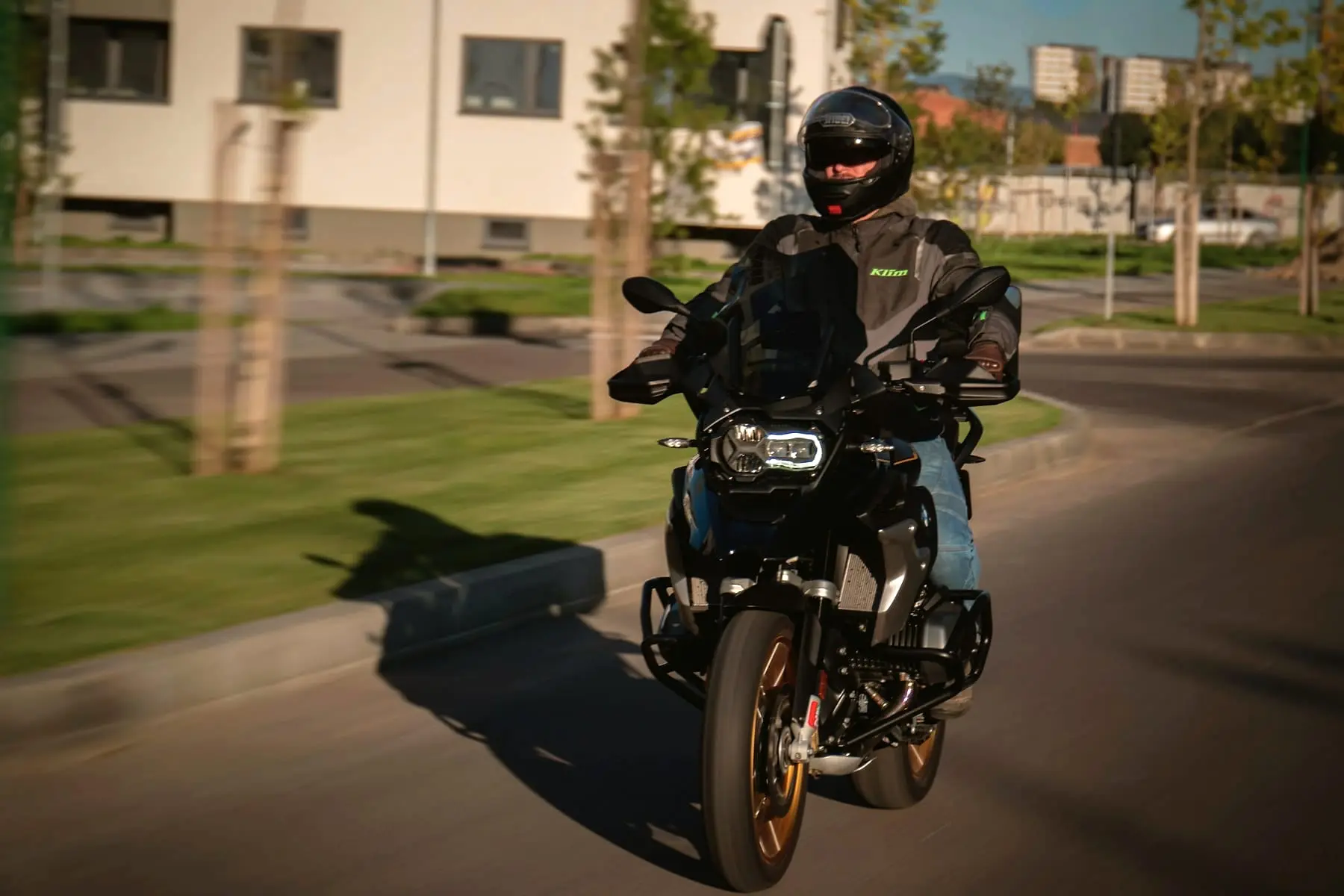 Motard roulant dans une rue résidentielle bordée d'arbres