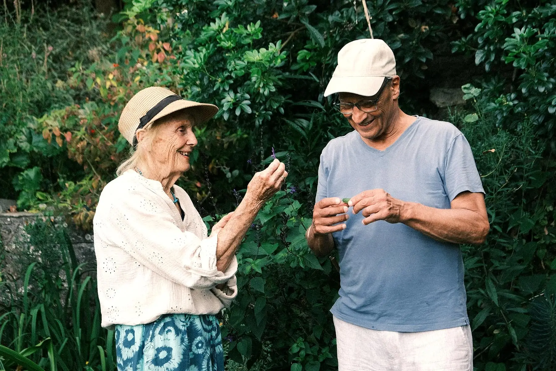 Couple de retraités complice dans un jardin verdoyant